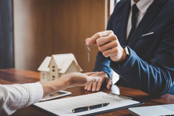 Real estate agent Sales manager holding filing keys to customer after signing rental lease contract of sale purchase agreement, concerning mortgage loan offer for and house insurance.